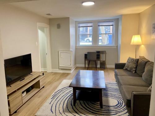 a living room with a couch and a flat screen tv at Lincoln Park Apartment with Backyard! in Chicago