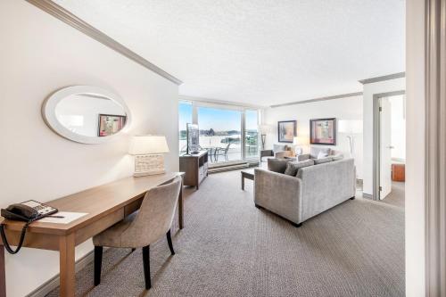 a living room with a desk and a couch at Victoria Regent Waterfront Hotel & Suites in Victoria