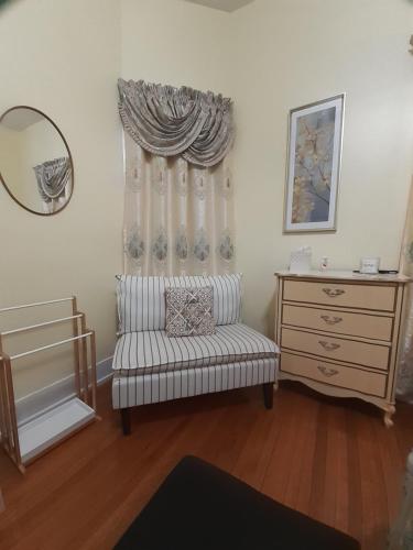 a living room with a chair and a dresser at Cozy Turret Room at Nottingham Place in Wise with Plush Queen Bed, Private Detached Full Bath in Wise