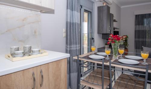 a kitchen with a table with glasses of wine at Liri's Apartments in Kalamaki