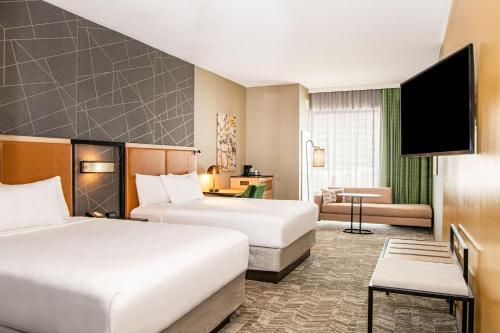 ボルチモアにあるSpringHill Suites by Marriott Baltimore Downtown Convention Center Areaのベッド2台とソファが備わるホテルルームです。