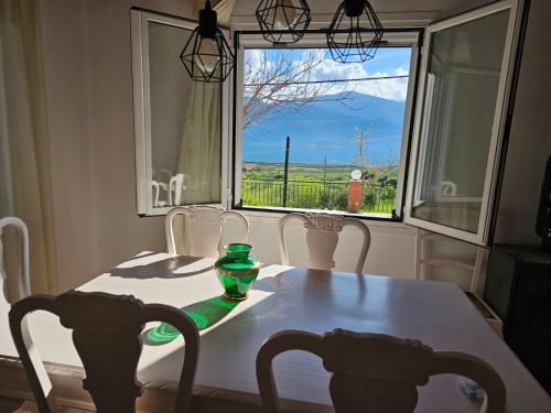 a table with chairs and a window with a view at Melidron in Lixouri