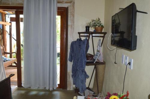 soggiorno con accappatoio blu appeso al muro di a casinha a Serra Grande
