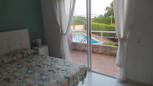 una camera con letto e un balcone con piscina di Casa Mistral a Palamós