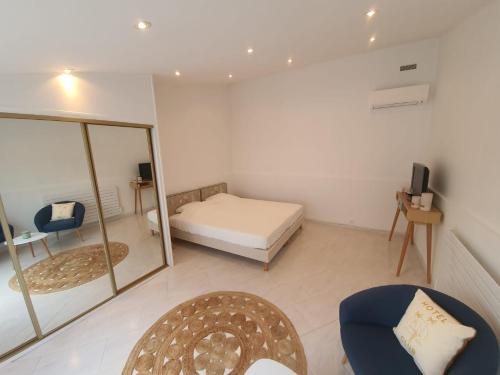 une chambre avec un lit, un miroir et une chaise dans l'établissement La Villa Émeraude, à Flayosc