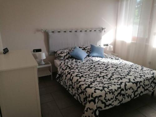 una camera da letto con un letto bianco e nero con cuscini blu di Blue House a Borgomanero