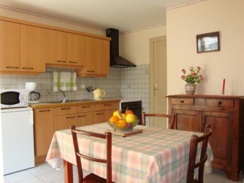 una cocina con una mesa con un bol de fruta. en La Perrière, en Chindrieux