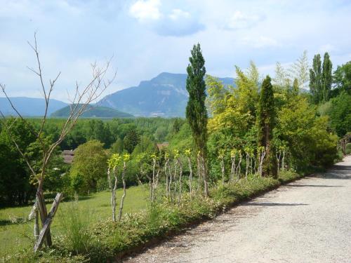 eine unbefestigte Straße mit Bäumen und einem Berg in der Ferne in der Unterkunft La Perrière in Chindrieux