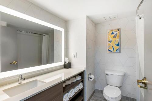 a bathroom with a sink and a toilet and a mirror at Comfort Inn & Suites Hampton near Coliseum in Hampton