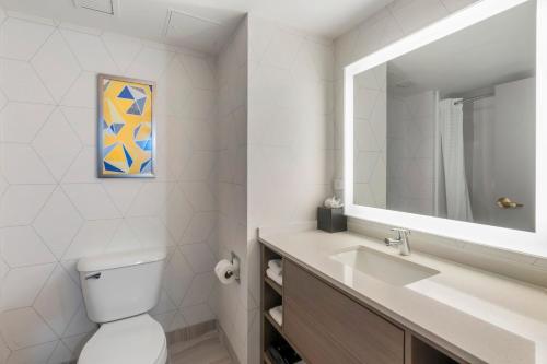 a bathroom with a sink and a toilet and a mirror at Comfort Inn & Suites Hampton near Coliseum in Hampton