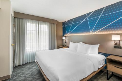 a hotel room with a large bed and a window at Comfort Inn & Suites Hampton near Coliseum in Hampton