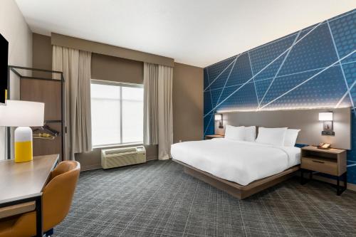 Comfort Inn & Suites Hampton near Coliseum في هامبتون: غرفة الفندق بسرير كبير ومكتب