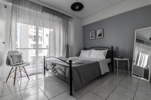 a bedroom with a bed and a chair and a window at Thanos Luxury home in Volos