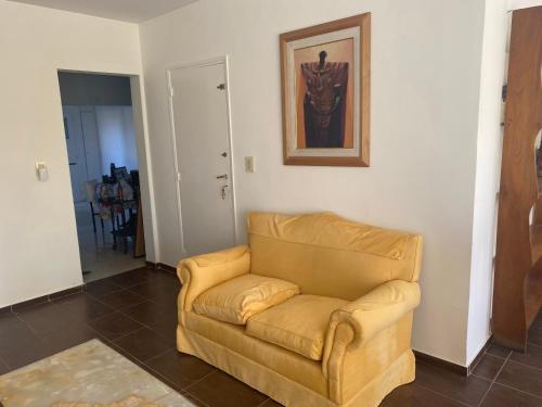 una sala de estar con sofá y una pintura en la pared en Departamento los andes en Mendoza