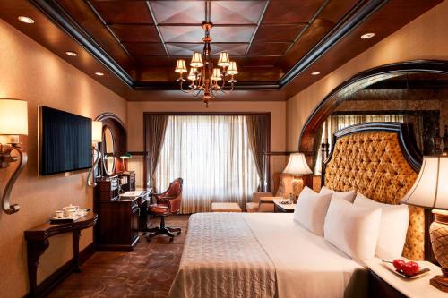 Cette chambre comprend un grand lit et un bureau. dans l'établissement Le Meridien New Delhi, à New Delhi