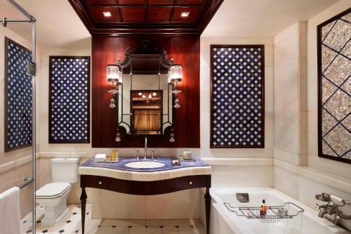 a bathroom with a sink and a tub and a toilet at Le Meridien New Delhi in New Delhi