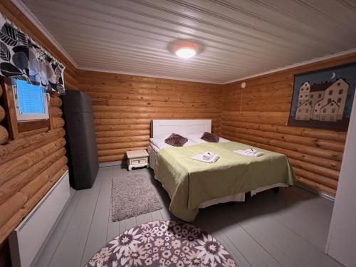 1 dormitorio con 1 cama en una habitación de madera en Rantakatti Apartments, en Punkaharju