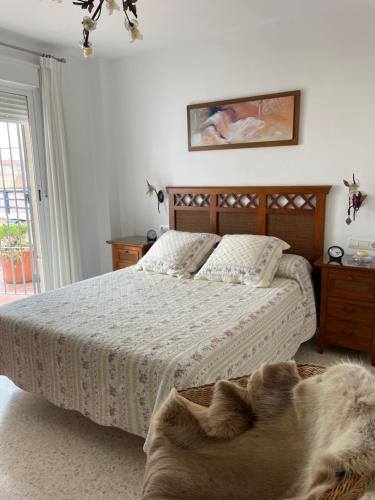 a dog laying on a bed in a bedroom at ÁTICO BAJO GUÍA in Sanlúcar de Barrameda