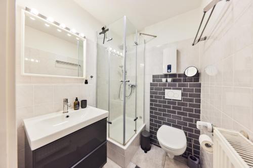 uma casa de banho com um lavatório, um chuveiro e um WC. em Kvartier2 in TOP-Lage, 5 min zur Bali-Therme und GOP, HDZ, Arbeitsplatz, Boxspringbett em Bad Oeynhausen