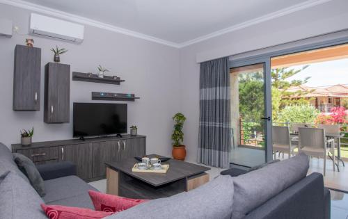 a living room with a couch and a tv at Liri's Apartments in Kalamaki