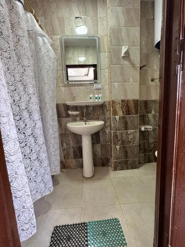 een badkamer met een wastafel en een spiegel bij Pyramids Family Inn in Caïro
