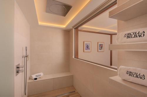 a bathroom with a mirror and a sink at Hotel Ercilla de Bilbao, Autograph Collection in Bilbao