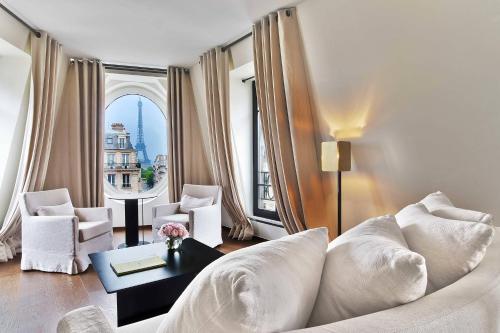 a living room with a white couch and a large window at Le Metropolitan Paris Tour Eiffel, a Tribute Portfolio Hotel in Paris