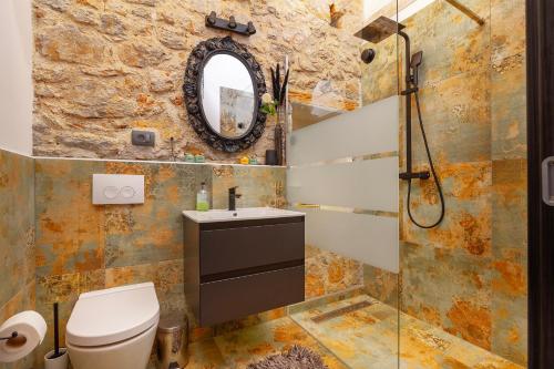 a bathroom with a toilet and a sink and a mirror at Apartments Kleine Perle Am Meer in Šilo