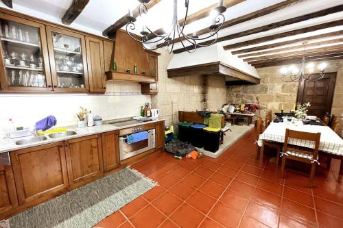 a kitchen with wooden cabinets and a table and a dining room at Casa do Rocio in Várzea de Abrunhais
