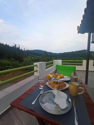 einen Tisch mit Teller mit Speisen auf dem Balkon in der Unterkunft Villa Sandra in Panormos Skopelos