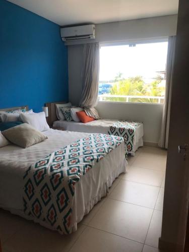 Duas camas num quarto com uma janela grande em São Pedro Resort em Piracicaba