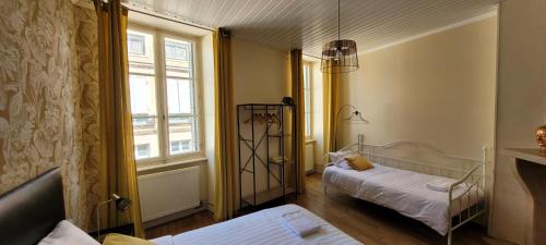 a small room with two beds and a window at Des Histoires d'Anges - Côté Ville - 2 meublés classés - Accueil Vélo in Tournus
