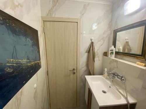 a bathroom with a sink and a painting on the wall at Bohemian House Kapana Central in Plovdiv