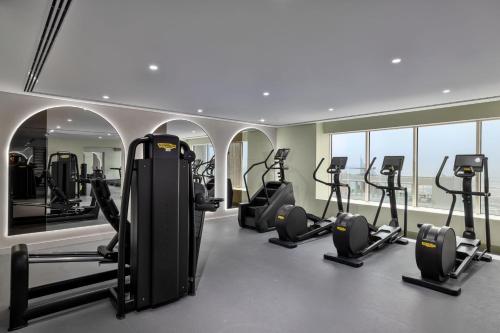 a gym with several treadmills and elliptical machines at Residence Inn by Marriott Sheikh Zayed Road, Dubai in Dubai