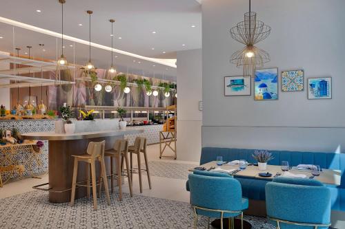 a restaurant with a bar with blue stools at Residence Inn by Marriott Sheikh Zayed Road, Dubai in Dubai