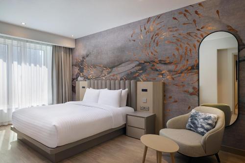 a bedroom with a bed and a wall with a painting at Residence Inn by Marriott Sheikh Zayed Road, Dubai in Dubai