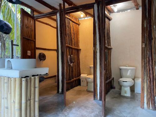 a bathroom with a toilet and a sink in it at La Aldea Holbox Cabañas y Camping in Holbox Island