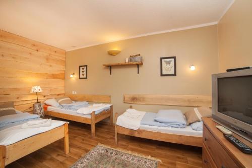 a room with two beds and a flat screen tv at Pensjonat Iskra in Sztum