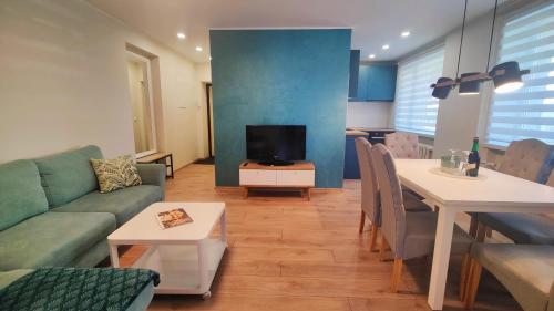 ein Wohnzimmer mit einem Sofa, einem Tisch und einem TV in der Unterkunft Jannseni apartment in Pärnu