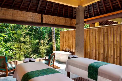 a room with two beds and chairs on a patio at Element Bali Ubud in Ubud