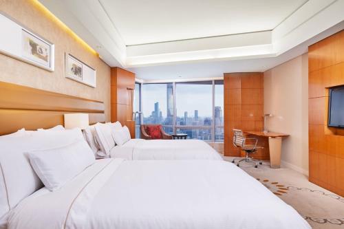 a hotel room with two beds and a television at The Westin Nanjing Xuanwu Lake in Nanjing