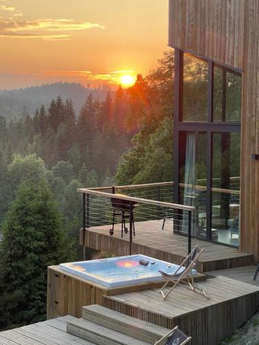 a house with a plunge pool on a deck with the sunset at Widokownia Brenna in Brenna