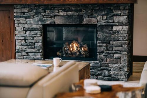 a living room with a stone fireplace at Tremblant Prestige - Étoile 1500-5 in Mont-Tremblant
