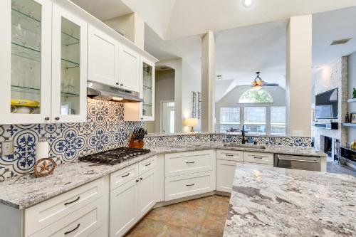 a kitchen with white cabinets and marble counter tops at Spacious Flower Mound Home in Central Location! in Flower Mound