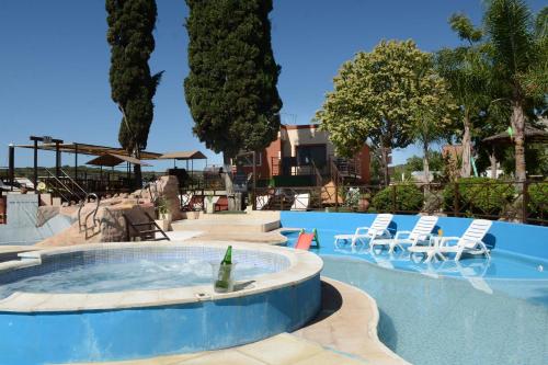 a swimming pool with a bottle in the middle of it at Complejo Los Cipreses in Villa Carlos Paz