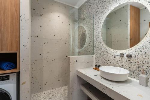 een badkamer met een wastafel en een spiegel bij Ble Residence, Your Home Away from Home in Panormos Rethymno