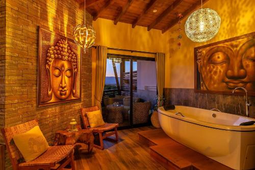 uma casa de banho com banheira e duas máscaras na parede em Shiva Boutique Hotel - Praia do Rosa em Praia do Rosa