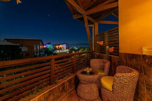 two chairs and a table on a balcony at night at Shiva Boutique Hotel - Praia do Rosa in Praia do Rosa