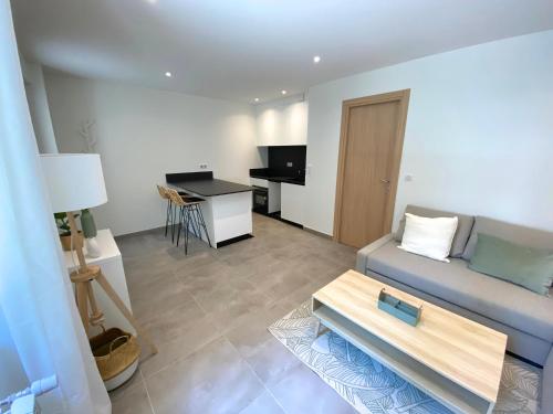 un salon avec un canapé et une table dans l'établissement T2 Neuf, parking & garage privé, proche centre, à Sarlat-la-Canéda