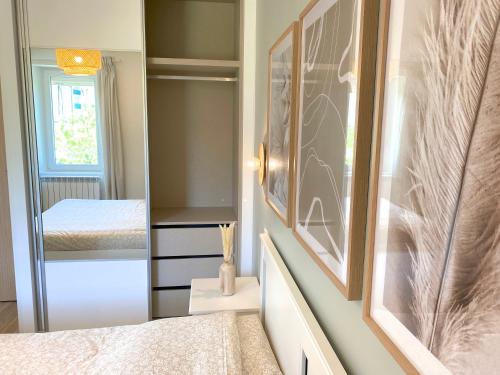 Dormitorio pequeño con cama y espejo en T2 Neuf, parking & garage privé, proche centre, en Sarlat-la-Canéda